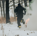 DALL·E 2023-02-13 22.51.54 - Police officer running away while on fire. Snowy woods, cold season.png